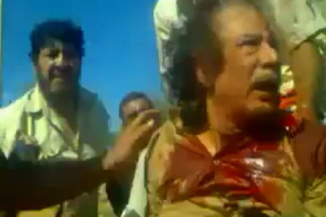 Frame grab shows former Libyan leader Muammar Gaddafi, covered in blood, after his capture by NTC fighters in Sirte