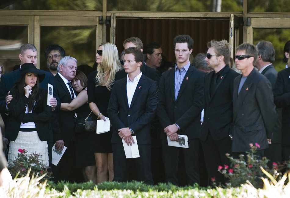 Friends of IndyCar driver Dan Wheldon look on as his casket is loaded into a hearse outside the First Presbyterian Church of St. Petersburg during a funeral service in St. Petersburg