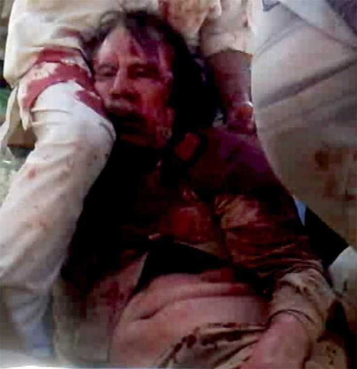 Frame grab of former Libyan leader Moammar Gadhafi, covered in blood, being held on the ground by NTC fighters in Sirte