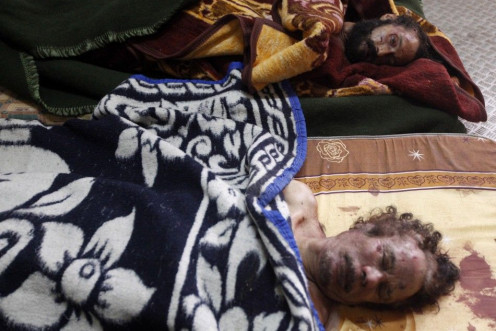 Dead bodies of Gaddafi and his son are displayed inside a metal storage freezer in Misrata
