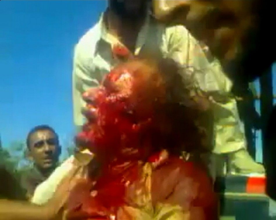 Frame grab shows former Libyan leader Muammar Gaddafi, covered in blood, after his capture by NTC fighters in Sirte