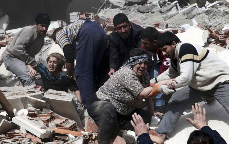 Rescue workers rescue people trapped under debris after an earthquake in a village near the eastern Turkish city of Van