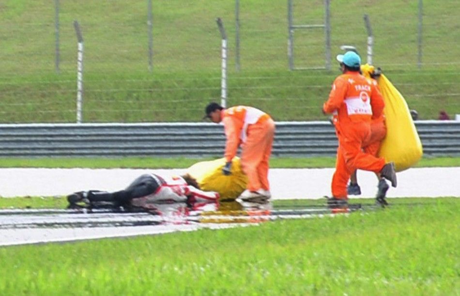 Honda MotoGP039s Marco Simoncelli of Italy lies on the ground after a crash during the Malaysian Grand Prix in Sepang