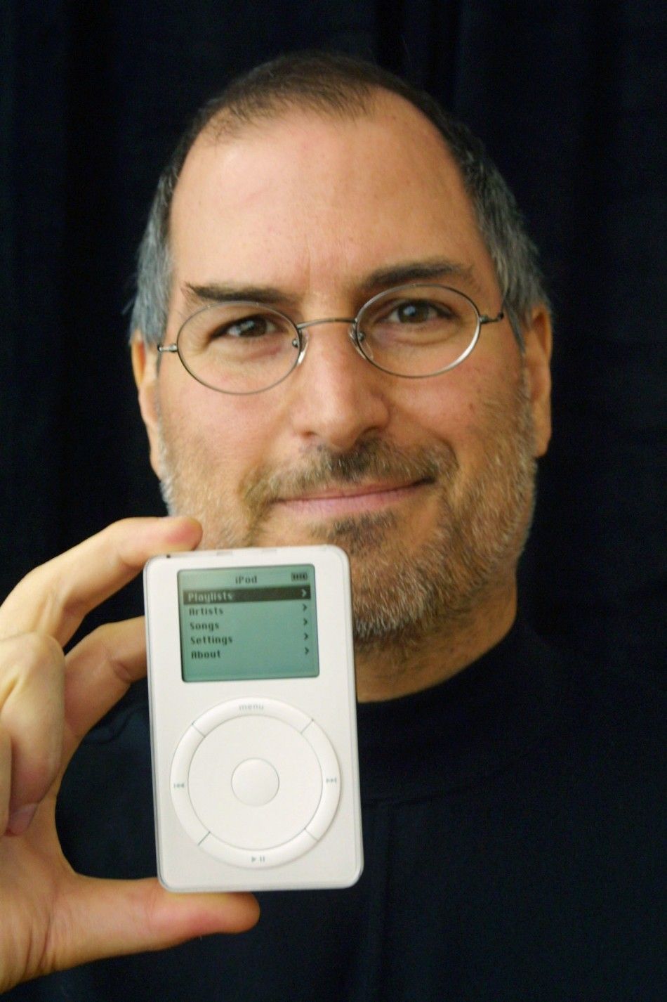 Apple Computer CEO Steve Jobs holds up the new Apple release iPod in Cupertino, California October 23, 2001. The new MP3 iPod music player packs up to 1,000 CD-quality songs into an ultra-portable, 6.5 ounce design that fits in your pocket.