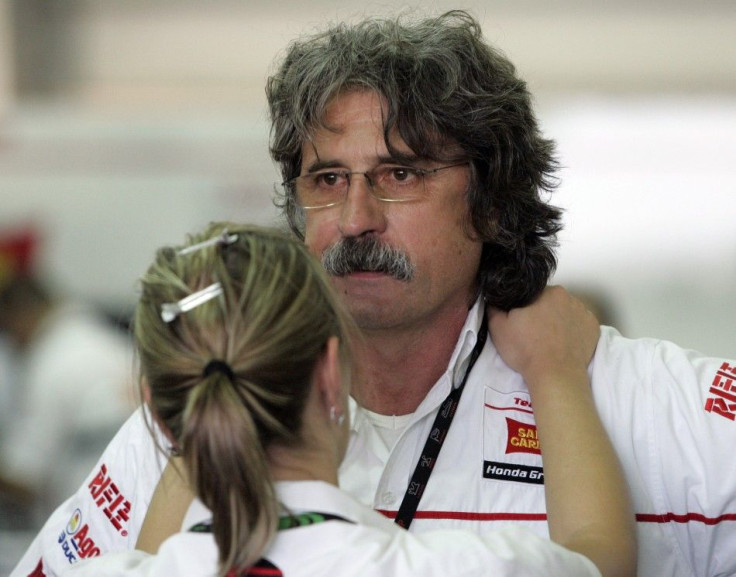 Paolo, the father of Marco Simoncelli of Italy, is consoled at the pit during the Malaysian Grand Prix in Sepang
