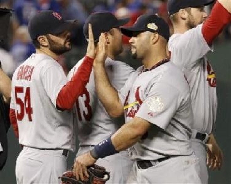 St. Louis Cardinals first baseman Albert Pujols (C) slaps hands with starting pitcher Jaime Garcia (54) after defeating the Texas Rangers in Game 3 of MLB&#039;s World Series baseball championship in Arlington, Texas