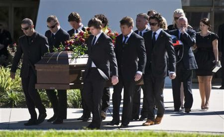 Pallbearers, including IndyCar drivers Tony Kanaan (L), Scott Dixon (third L) and Dario Franchitti (4th R) carry the casket of fellow driver Dan Wheldon as they escort Susie Wheldon (3rd R), Clive Wheldon and Ashley Wheldon (R) from the church during a fu