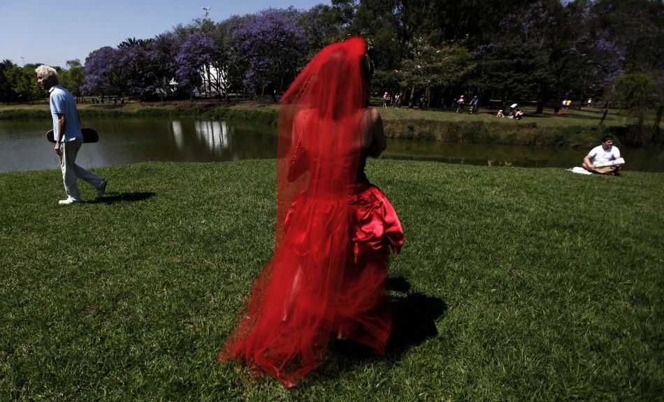 A woman in a red wedding gown uses her mobile phone during the quotParade of Bridesquot at Ibirapuera park in Sao Paulo