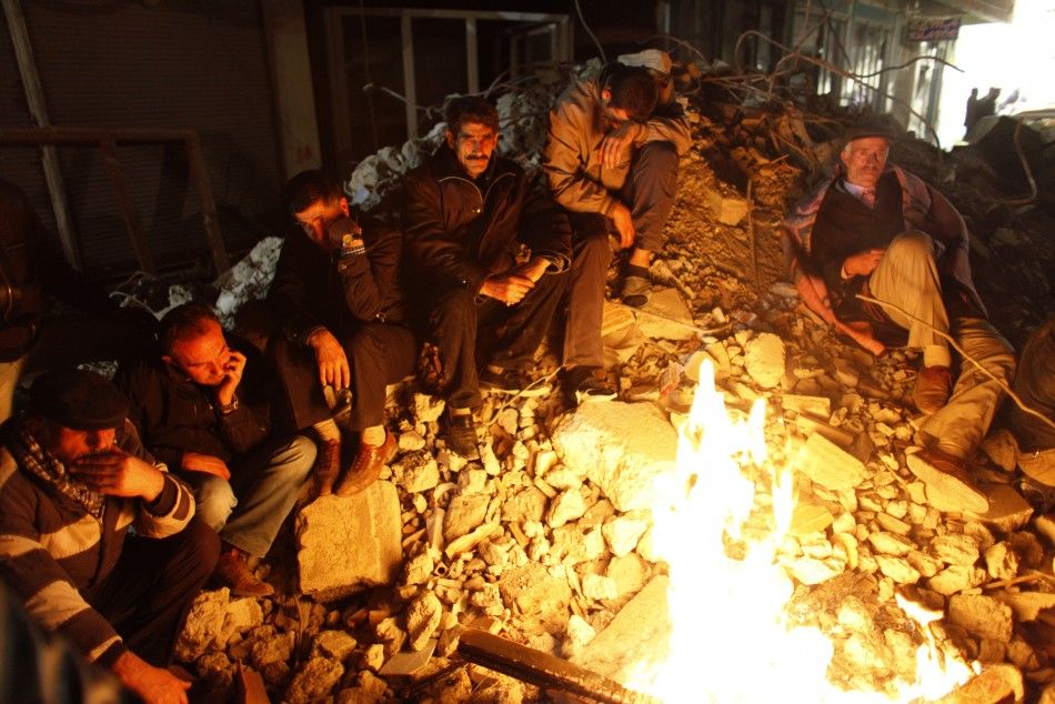 People sit on a pile of debris after an earthquake in Ercis, near the eastern Turkish city of Van early October 24, 2011