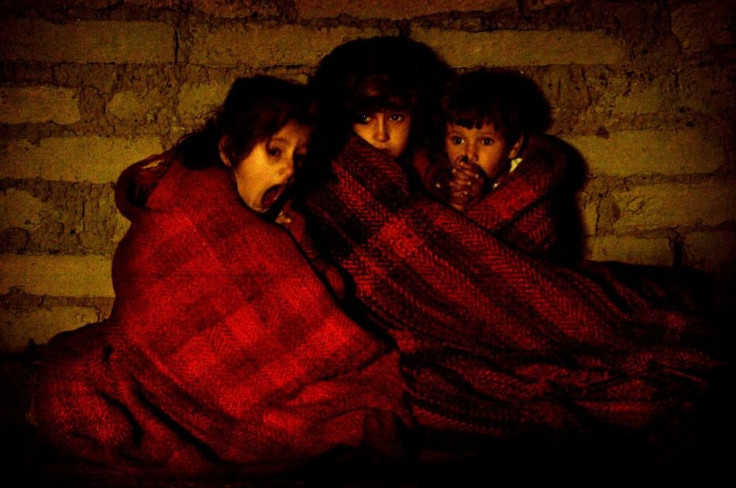 Terrified Iraqi children protect themselves from the cold after they&#039;re taken outside their house during a pre-dawn raid in a suburb of Baquba November 16, 2003. [Looking for members of a suspected terrorist cell who attacked coalition forces, troops