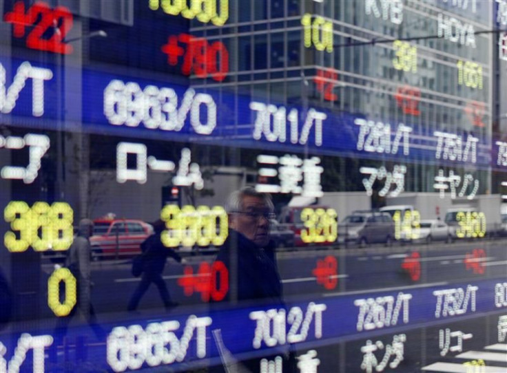 A man is reflected on a stock quotation board showing Japanese companies' stock prices outside a brokerage in Tokyo