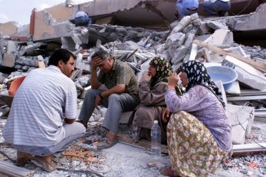 Residents sit in front of their destroyed apartment blocks in Izmit, Turkey.