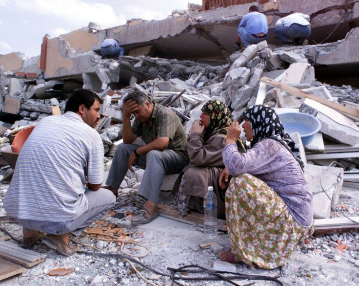 Residents sit in front of their destroyed apartment blocks in Izmit, Turkey.