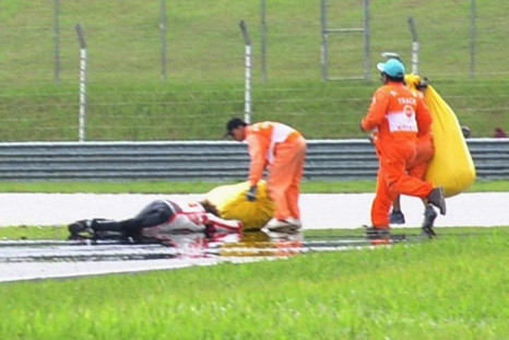 Honda MotoGP&#039;s Marco Simoncelli of Italy lies on the ground after a crash during the Malaysian Grand Prix in Sepang