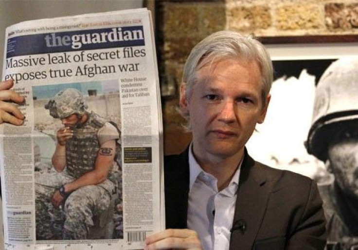 Wikileaks founder Julian Assange holds up a copy of the Guardian newspaper during a press conference at the Frontline Club in central London