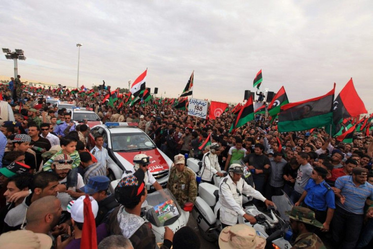 Police cars drive as people celebrate the liberation of Libya in Quiche