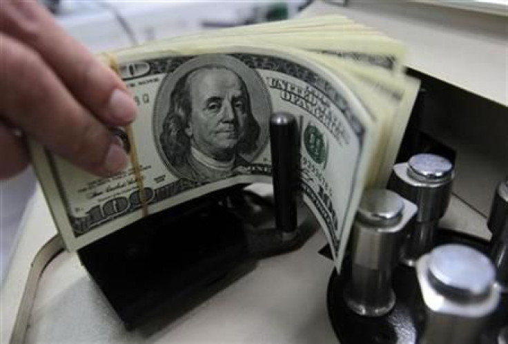 A bank employee counts U.S. hundred dollar bills