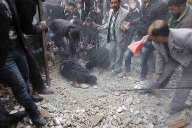 Turkish people search for survivors as they stand on the rubbles of a building which collapsed during an earthquake in Van