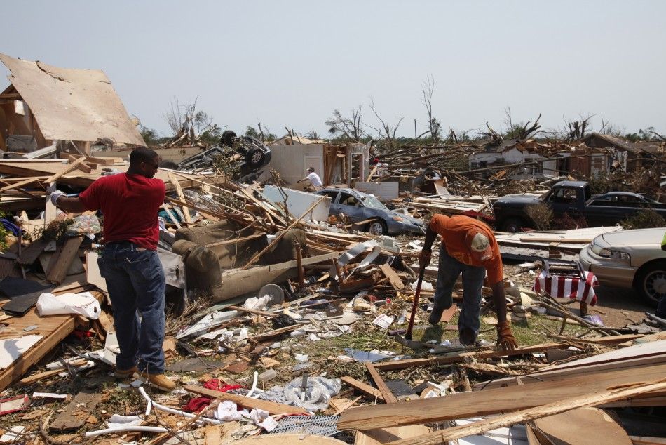 Men move debris in yard of friend the aftermath of deadly tornados in badly-damaged Alberta neighborhood of Tuscaloosa