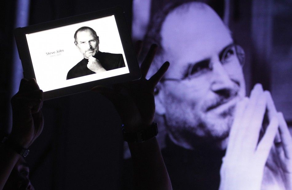 A man holds an iPad displaying a photo of Steve Jobs during a Steve Jobs Day memorial day event in Manila