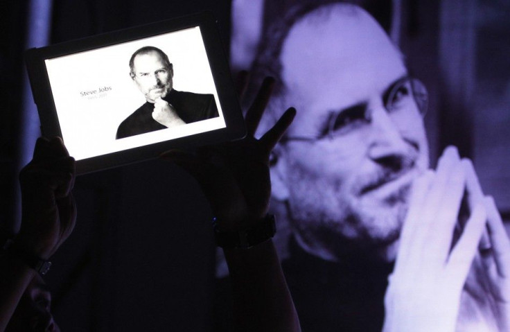 A man holds an iPad displaying a photo of Steve Jobs during a 'Steve Jobs Day' memorial day event in Manila
