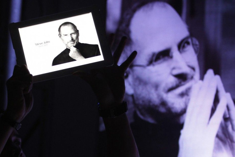 A man holds an iPad displaying a photo of Steve Jobs during a 'Steve Jobs Day' memorial day event in Manila
