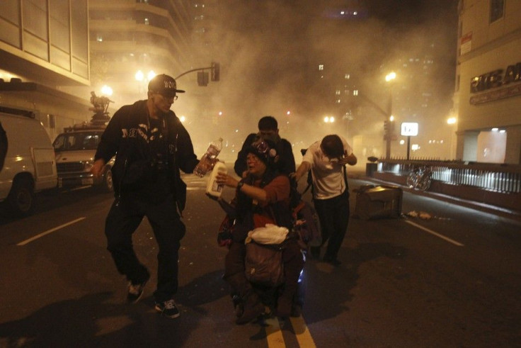 An Occupy Wall St. demonstrator in a wheelchair is pushed away as authorities deploy tear gas during an demonstration in response to an early morning police raid which displaced Occupy Oakland's tent city in Oakland, California