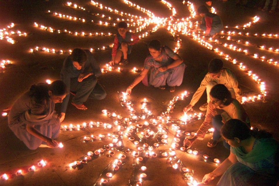 Indian women light lamps on eve of Diwali, the Hindu festival of lights