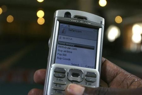 A man scrolls through his mobile phone to carry out a money transaction via M-PESA in Nairobi