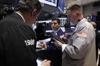 Traders work at the Bank of America trading post on the floor of the New York Stock Exchange