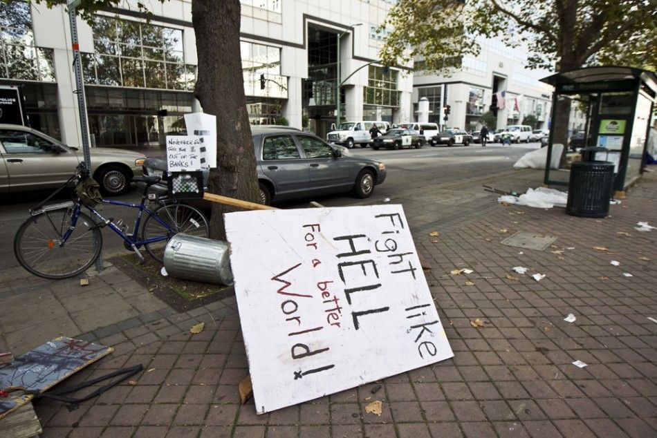 A protest sign lies on the sidewalk next to a closed down camp of anti-Wall Street protesters in Oakland