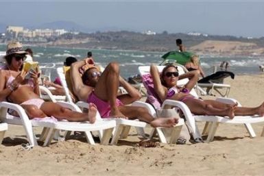 Tourists sunbathe on the beach in Tunisia