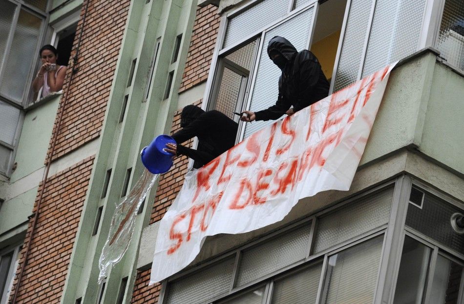 Stop Desahucios activists dump water on riot police to prevent them from executing a June 27 eviction in Oviedo, Spain.