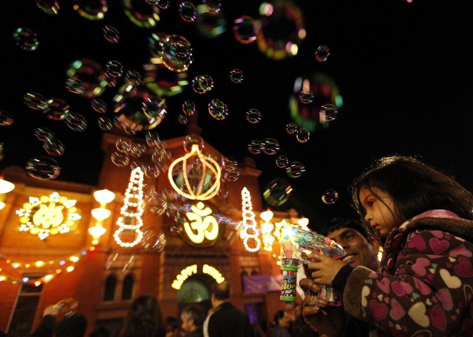 A girls shoots bubbles from a gun during the start of Diwali celebrations in Leicester