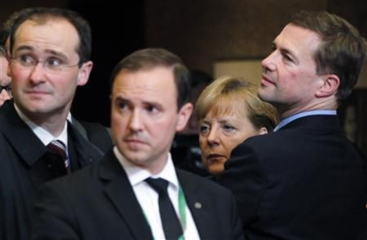 Germany&#039;s Chancellor Angela Merkel waits for her car as she leaves a euro zone leaders summit in Brussels