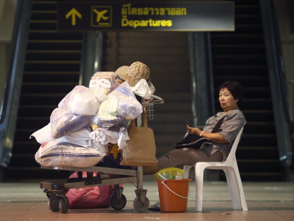 A flood victim waits for her transportation to be relocated to a new evacuation centre, at Don Muang Airport in Bangkok