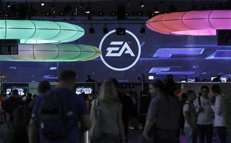 Visitors walk past the exhibition stand of Electronic Arts at the Gamescom 2010 fair in Cologne