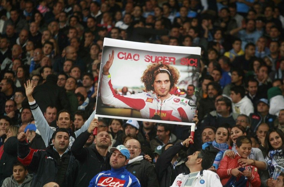 Napolis supporters hold a banner depicting Honda MotoGP rider Marco Simoncelli during their Serie A soccer match against Udinese at San Paolo stadium in Naples