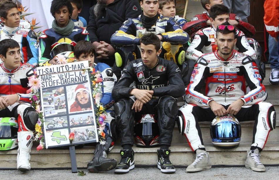Young riders wait for the coffin of Honda MotoGP rider Marco Simoncelli to arrive for his funeral service in Coriano