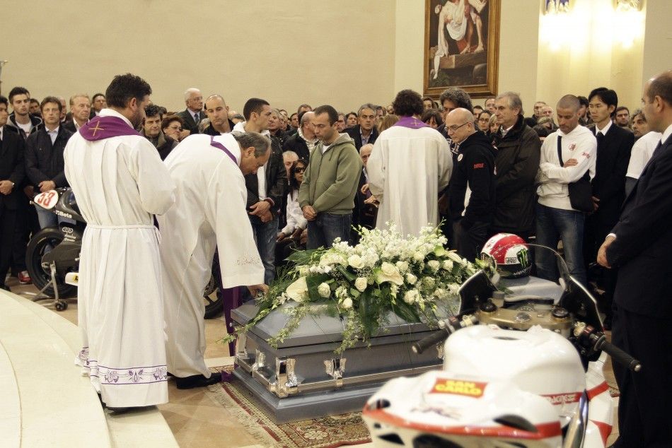 A priest blesses the coffin of Honda MotoGP rider Marco Simoncelli during his funeral service at a church in Coriano