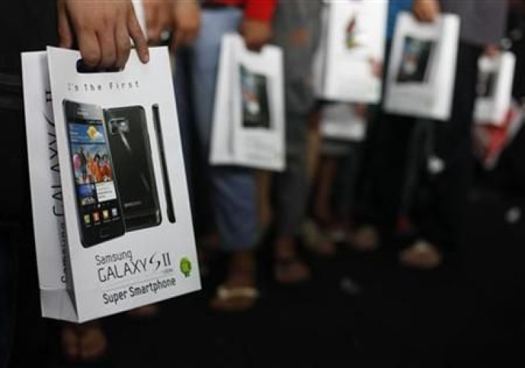 Customers hold their newly purchased Samsung Galaxy S2 android phone in Jakarta
