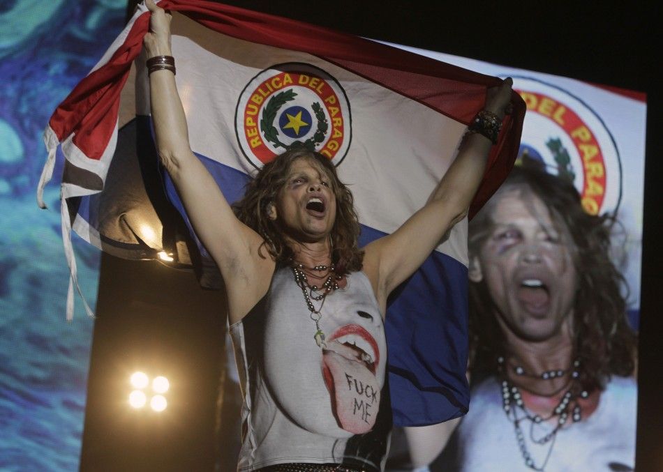 Steven Tyler of Aerosmith holds a Paraguayan national flag during a concert on the first stop of their Latin America tour at the Jockey Club in Asuncion October 26, 2011.