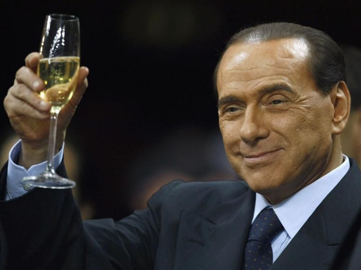 File photo of Italy&#039;s Prime Minister Berlusconi as he holds a glass of wine at San Siro stadium in Milan