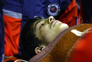 Rescuers transport Ferhat Tokay, 13, into an ambulance after he was pulled out of the rubble of a collapsed building in Ercis early October 28, 2011.