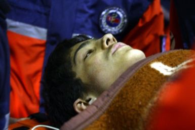 Rescuers transport Ferhat Tokay, 13, into an ambulance after he was pulled out of the rubble of a collapsed building in Ercis early October 28, 2011.