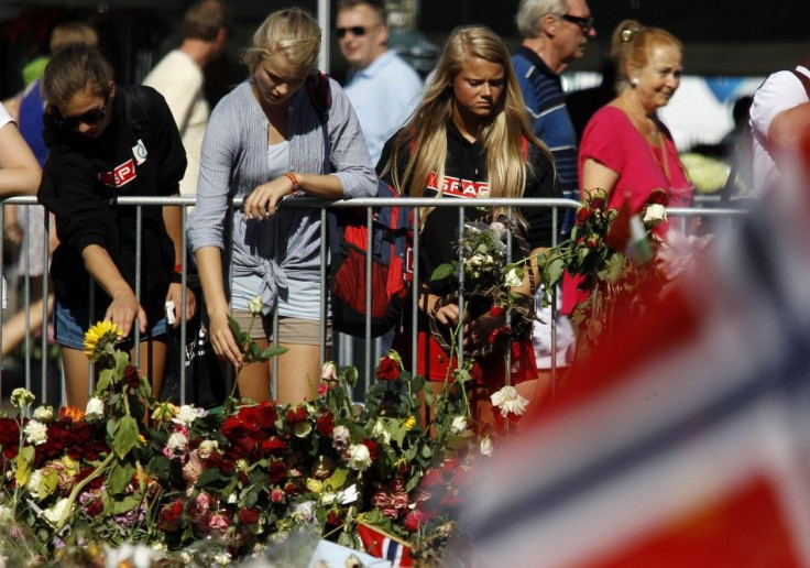 A woman cries as she pays her respects for the victims of attacks outside the Oslo cathedral 