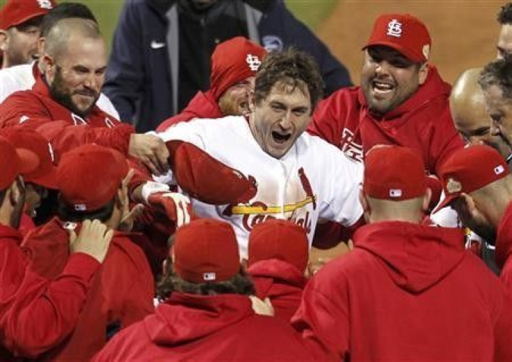 St. Louis Cardinals&#039; David Freese steps on home plate surrounded by his teammates after hitting the game winning home run against the Texas Rangers in the eleventh inning in Game 6 in St. Louis