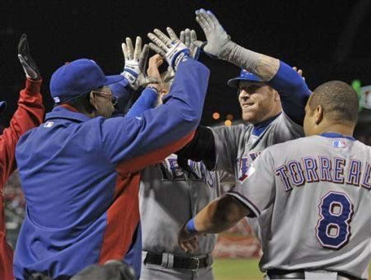 Texas Rangers&#039; Josh Hamilton (C) celebrates with manager Ron Washington (L) and Yorvit Torrealba (R) after hitting a two run home run against the St. Louis Cardinals during the tenth inning in Game 6 of MLB&#039; World Series baseball championship in