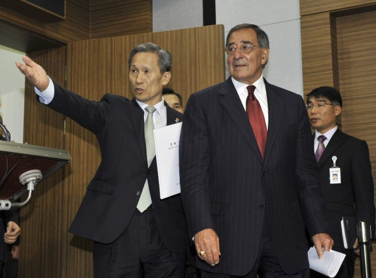 South Korean Defense Minister Kim ushers U.S. Defense Secretary Panetta towards a joint news conference in Seoul