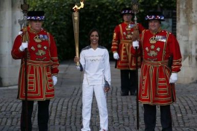 Britain&#039;s Holmes holds the London 2012 Olympic torch as she poses with Yeoman Warders at the Tower of London
